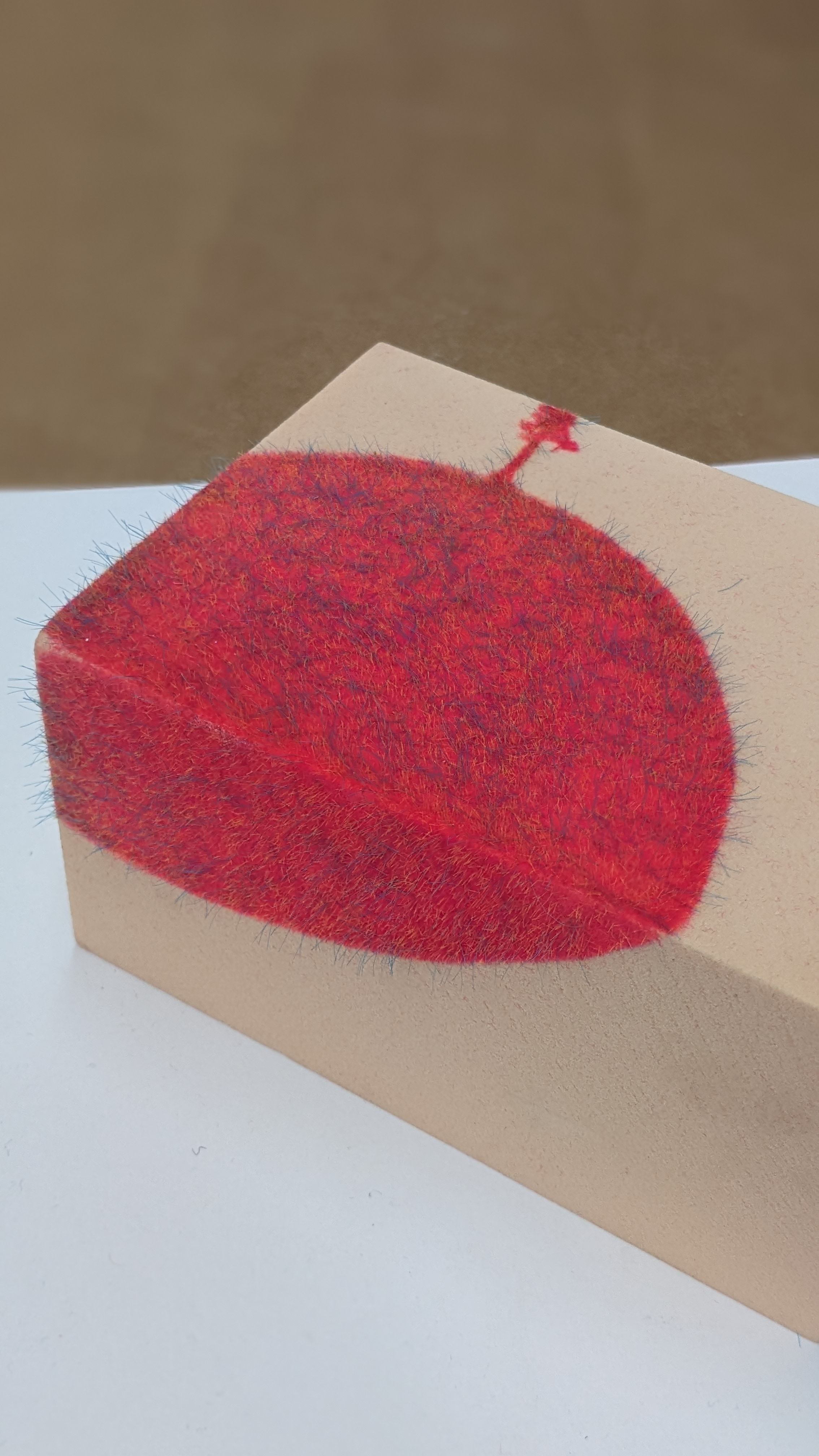 Piece of wood that has been used as an example for flocking - neon paint with threads that are raised due to an electric current that gets passed through the glue